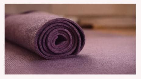 A rolled purple yoga mat